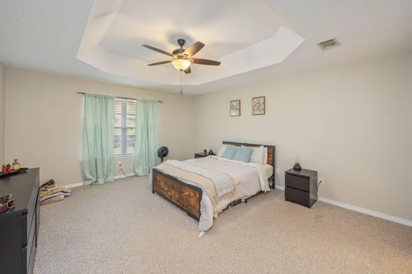 a spacious bedroom with a bed and a chandelier