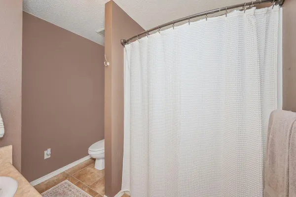 a bathroom with a toilet and shower curtain
