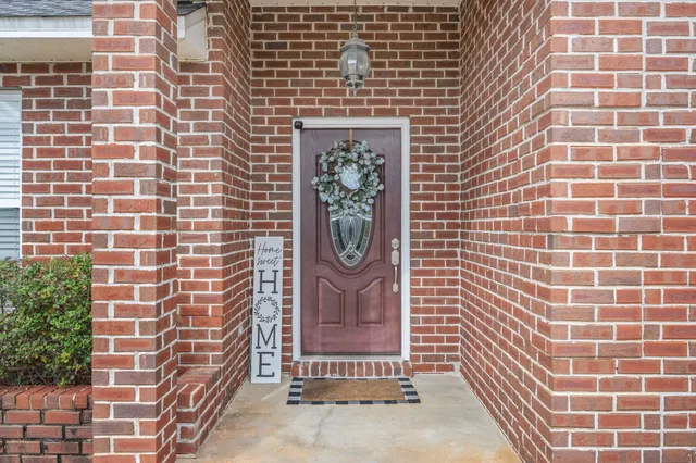a brick building with a door and a potted plant