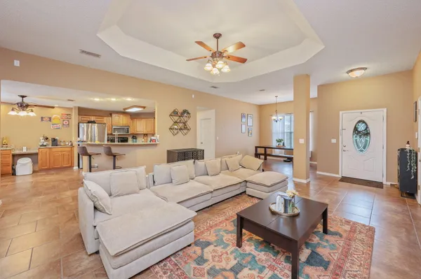 a living room with furniture and a view of kitchen