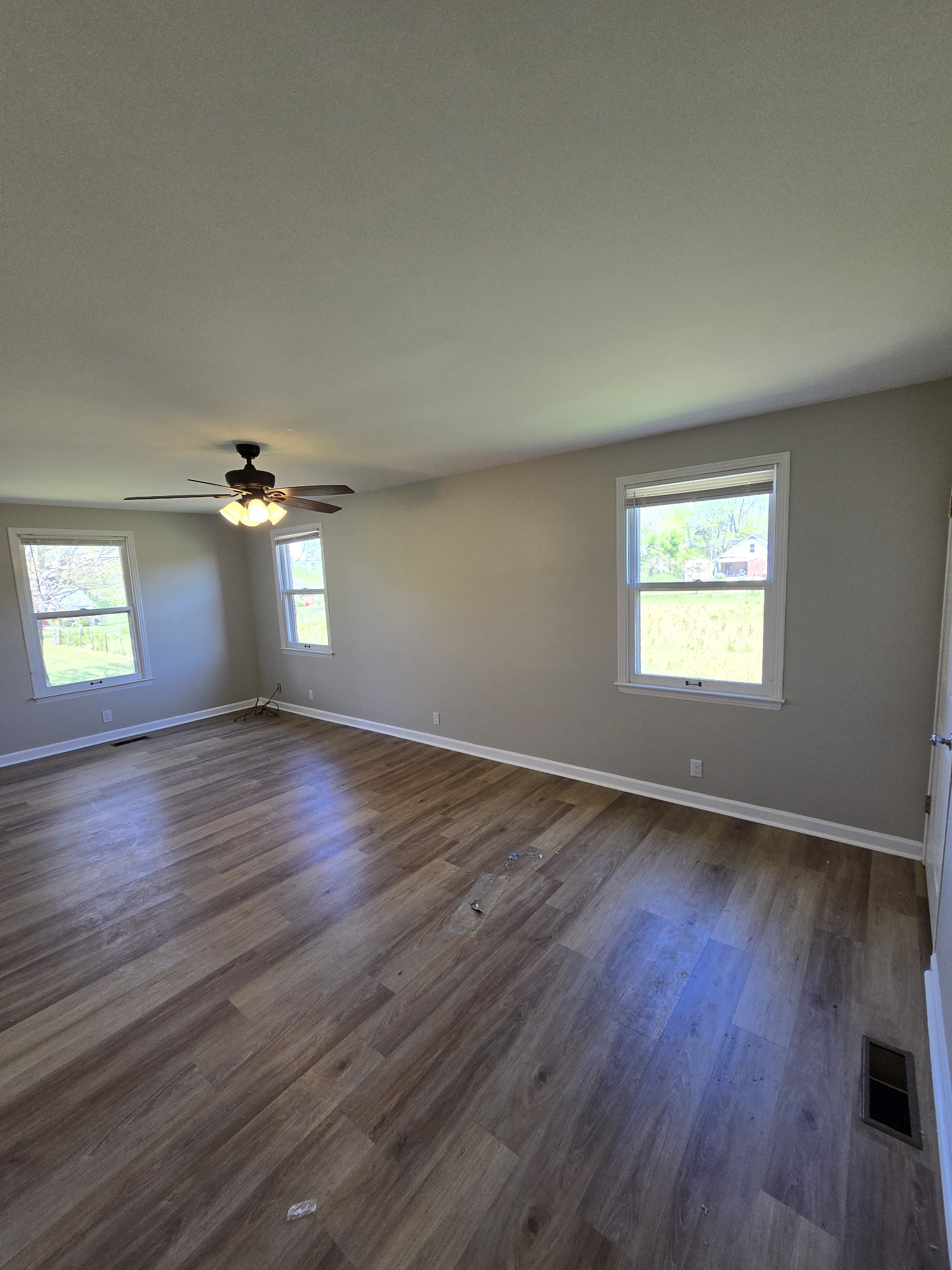 6350 Eatons Creek Road Joelton, TN 37080 - Photo 16 of 37 an empty room with wooden floor chandelier fan and windows