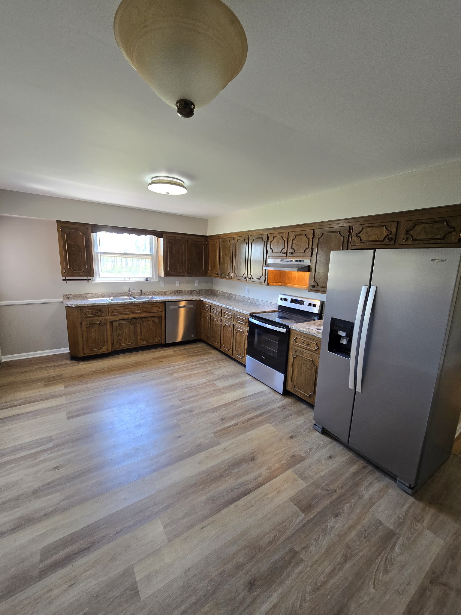6350 Eatons Creek Road Joelton, TN 37080 - Photo 19 of 37 a kitchen with stainless steel appliances wooden floor and a refrigerator