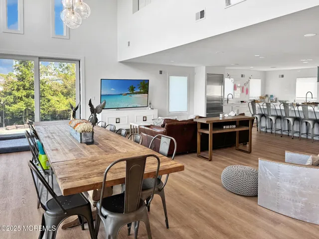 a kitchen with stainless steel appliances kitchen island granite countertop a table chairs sink and cabinets