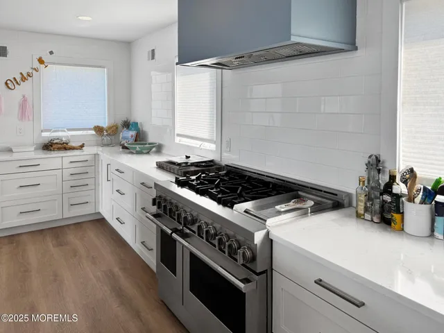 a living room with furniture kitchen view and a large window