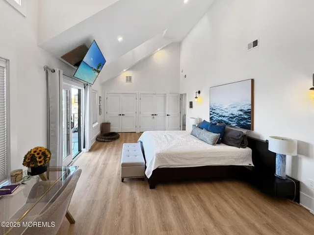 a bedroom with a bed and wooden floor