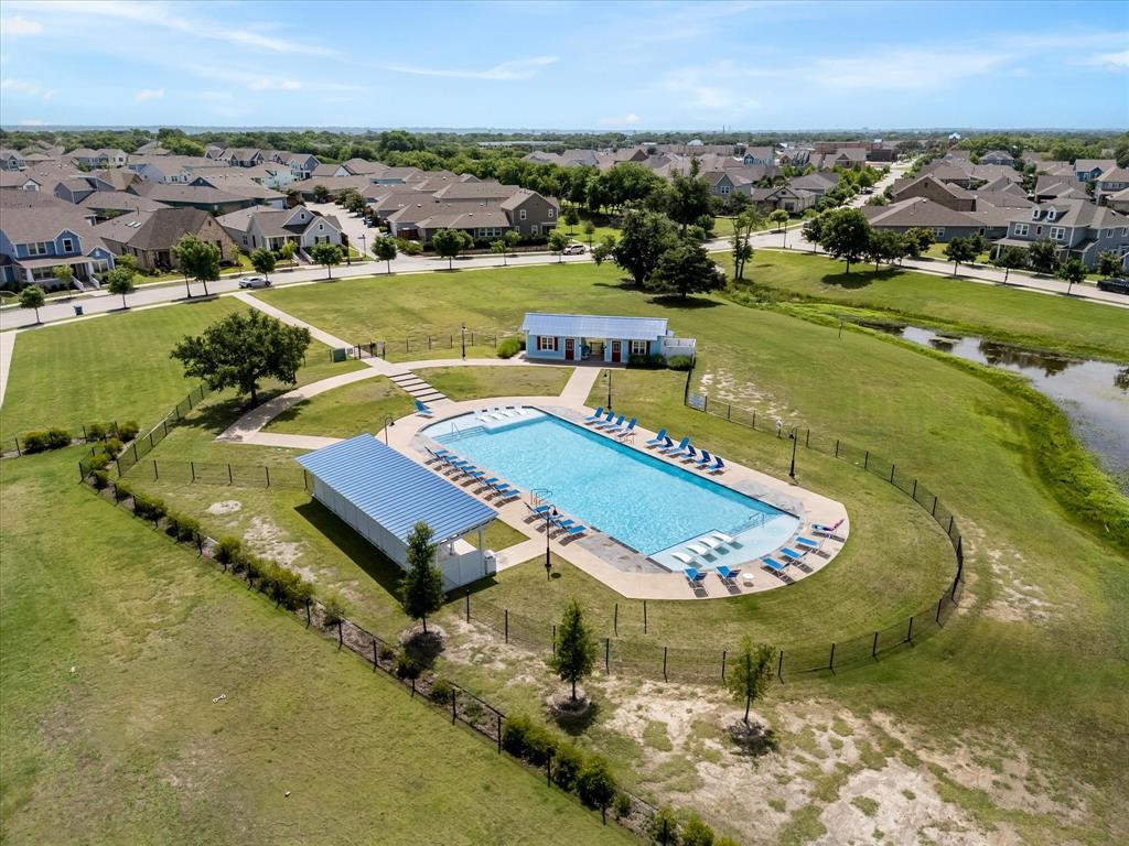 9224 Lamar Street Rowlett, TX 75089 - Photo 23 of 27 Community swimming pool with surrounding lounge chairs, covered shade structure, and a pool house