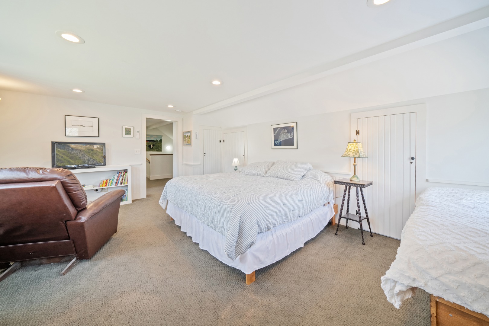 357 West Tisbury Road Edgartown, MA 02539 - Photo 19 of 33 a spacious bedroom with a bed a couch and dresser