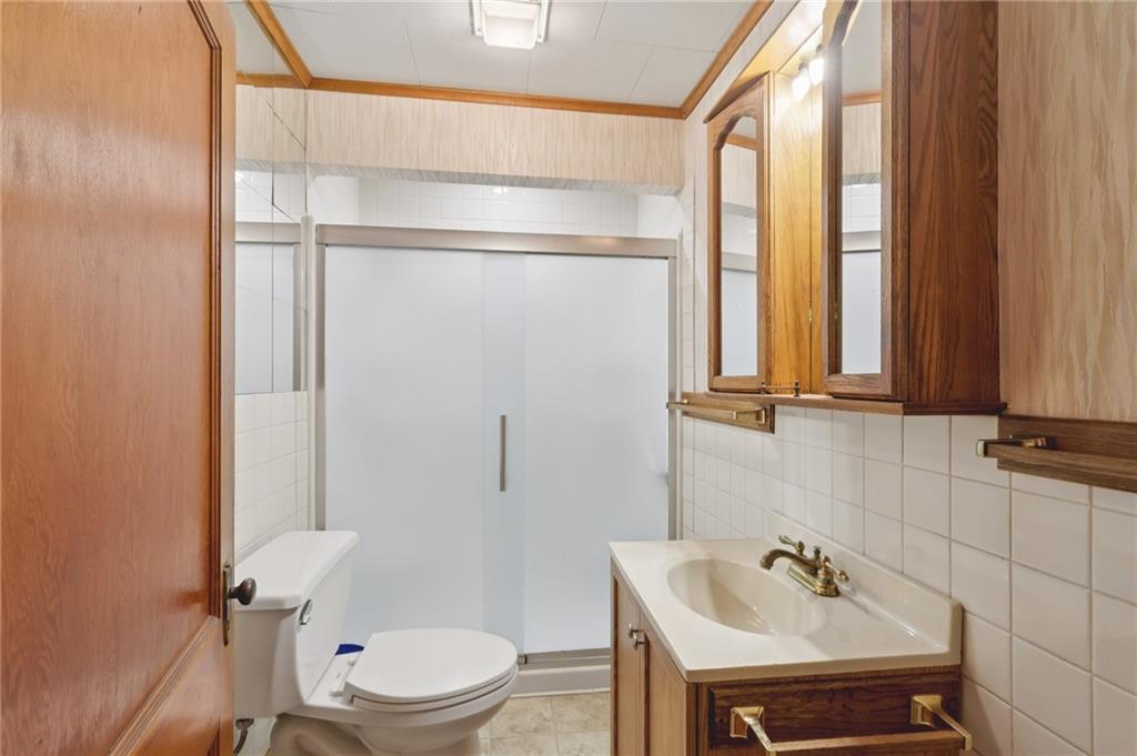 1111 Crowe Street New Castle, PA 16101 - Photo 15 of 37 a bathroom with a sink a toilet and a mirror