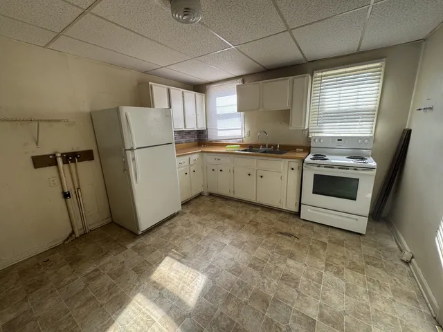 a kitchen with a sink a refrigerator and cabinets