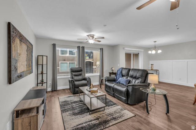905 South Main Street, Unit G Layton, UT 84041 - Photo 9 of 36 Living room featuring a ceiling fan, light wood finished floors, a chandelier, and a wainscoted wall