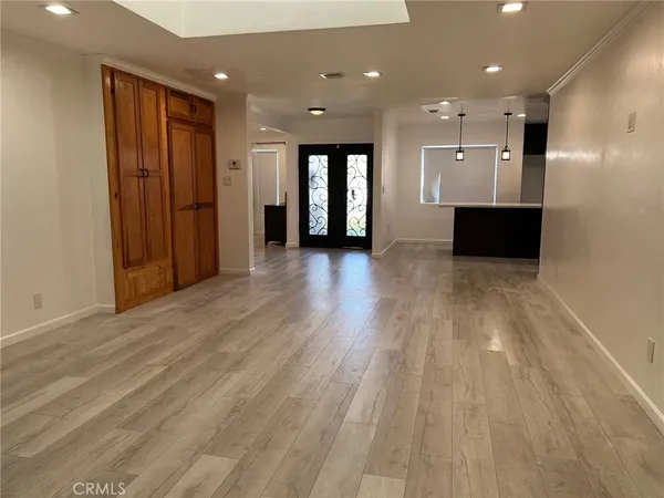 an empty room with wooden floor and natural light
