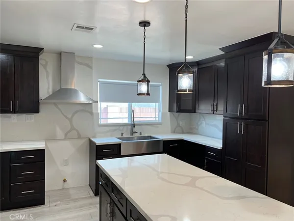 a kitchen with kitchen island a sink stainless steel appliances and cabinets