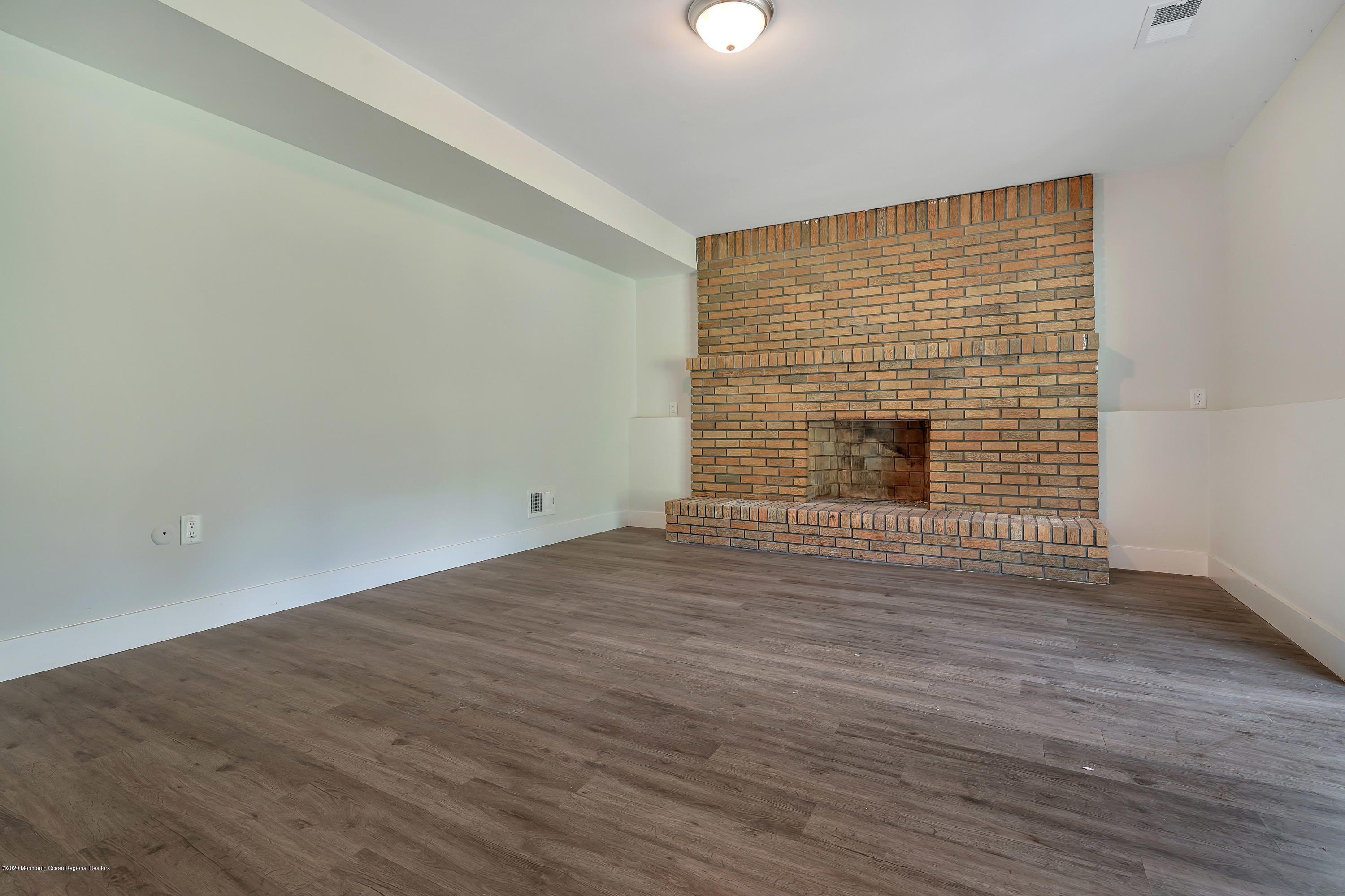 30 Jackson Mills Road Jackson, NJ 08527 - Photo 24 of 37 an empty room with wooden floor and fireplace