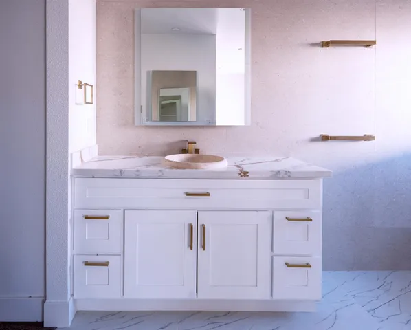 a bathroom with a sink vanity and a mirror