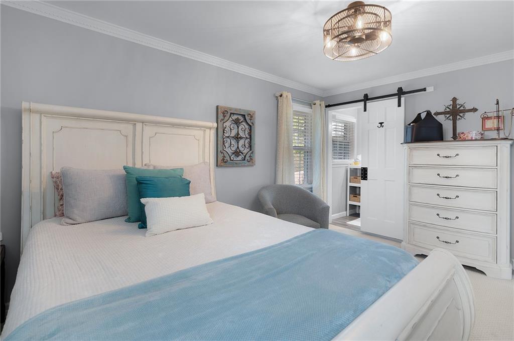 136 Meadow Lane Calhoun, GA 30701 - Photo 23 of 34 a bedroom with a large bed and a chandelier