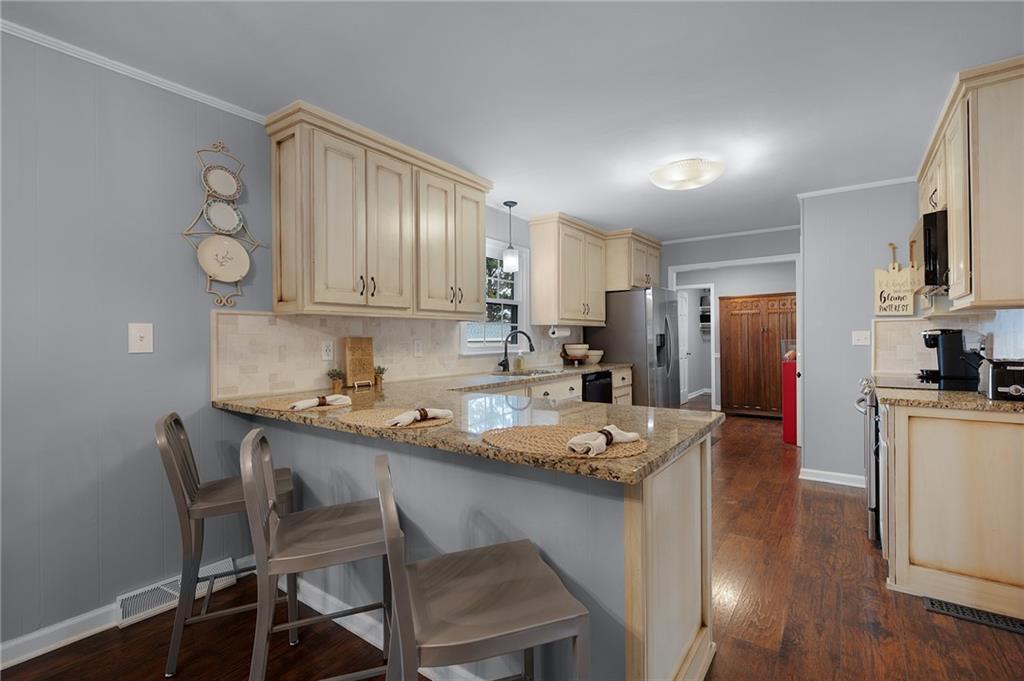 136 Meadow Lane Calhoun, GA 30701 - Photo 10 of 34 a kitchen with a dining table chairs refrigerator and cabinets