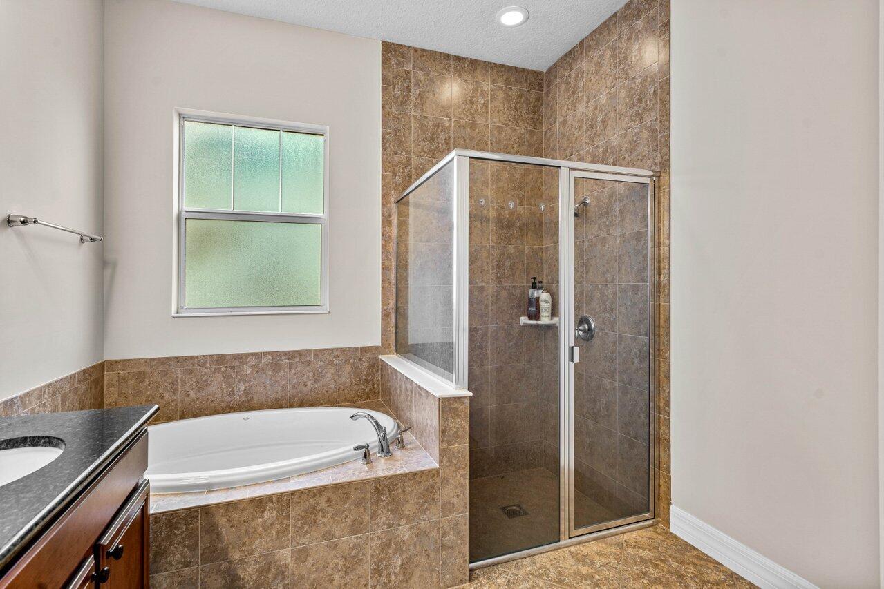 1131 North Prescott Drive Jupiter, FL 33458 - Photo 23 of 72 a bathroom with a tub and shower
