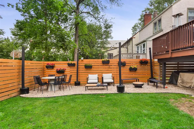 a view of a patio with table and chairs potted plants and large tree