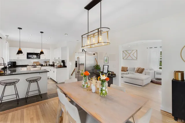 a living room with furniture a rug kitchen view and a chandelier