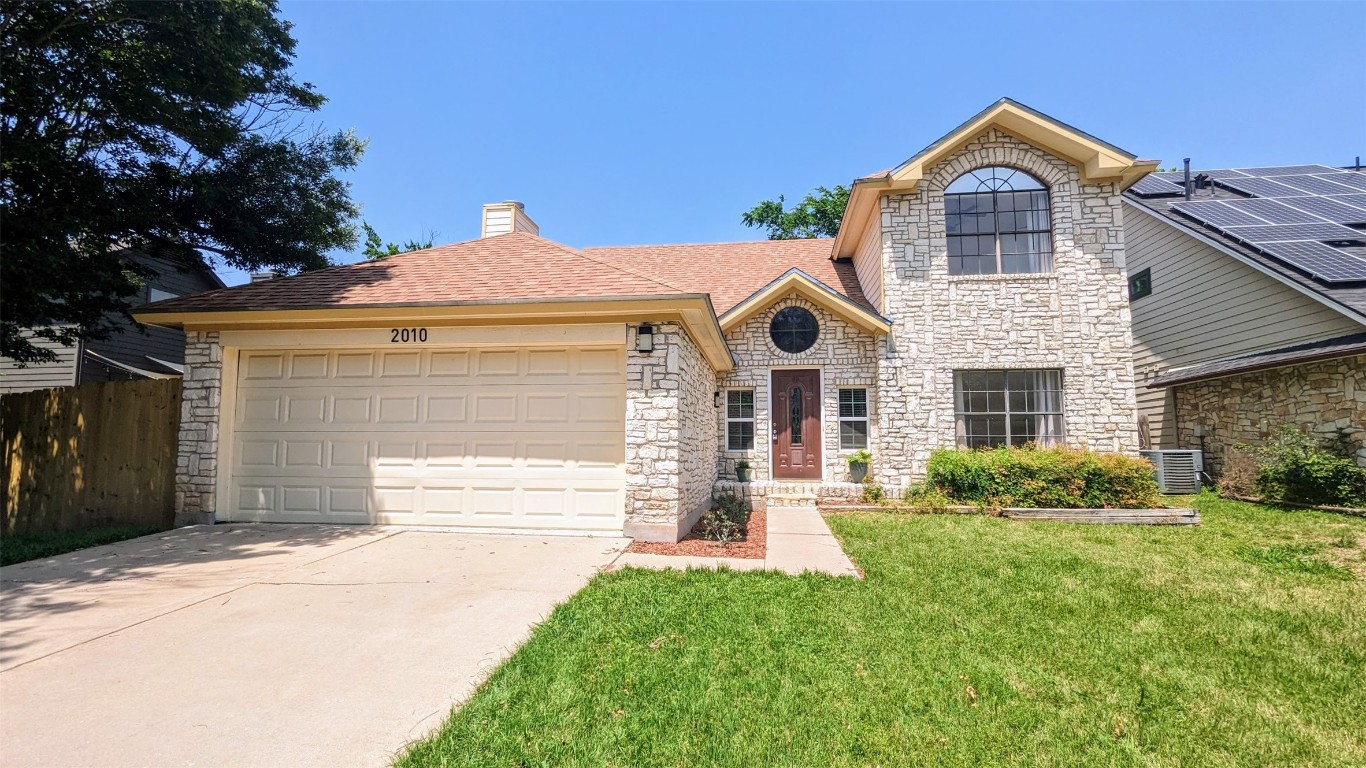 a front view of a house with a yard and garage
