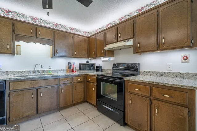 a kitchen with granite countertop a sink stainless steel appliances and cabinets