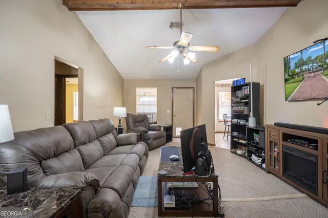 a living room with furniture a flat screen tv and a window
