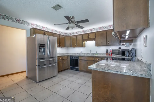 a kitchen with stainless steel appliances granite countertop a sink a stove and a refrigerator