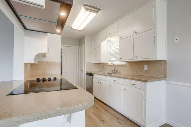 a kitchen with granite countertop a sink a stove and cabinets