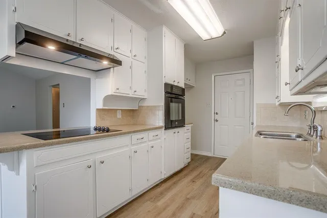 a kitchen with stainless steel appliances granite countertop a sink and a stove