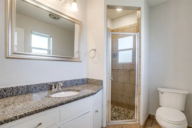 a bathroom with a granite countertop sink toilet and shower