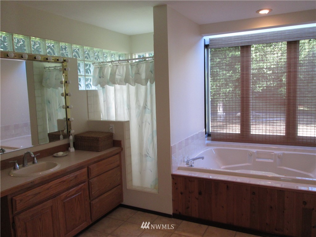 19611 Whiteman Cove Road Southwest Longbranch, WA 98351 - Photo 14 of 25 a bathroom with a double vanity sink and a bathtub