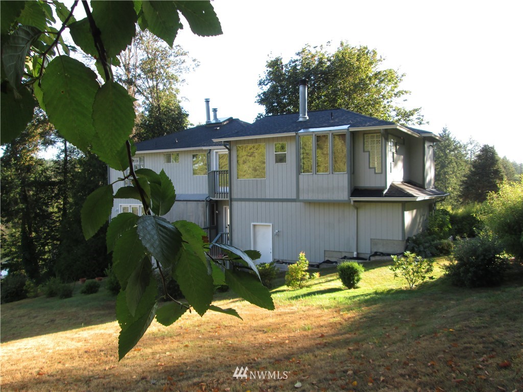 19611 Whiteman Cove Road Southwest Longbranch, WA 98351 - Photo 3 of 25 a view of a yard in front of a house with large tree