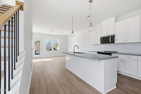 a view of kitchen with stainless steel appliances cabinets and wooden floor
