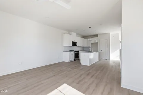 a large white kitchen with a stove a sink dishwasher and a refrigerator