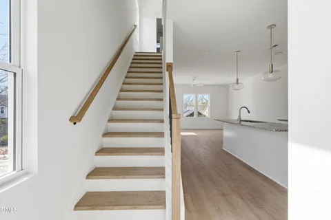 a view of a hallway with wooden floor and staircase