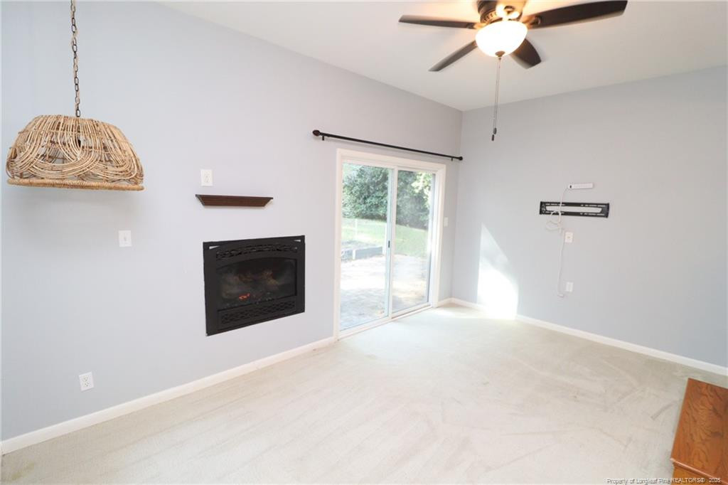 4909 Auburn Road Raleigh, NC 27609 - Photo 16 of 33 a view of a room with a ceiling fan and a fireplace