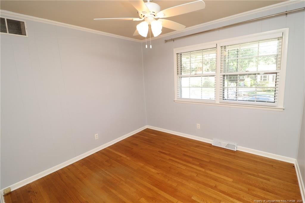 4909 Auburn Road Raleigh, NC 27609 - Photo 19 of 33 an empty room with wooden floor fan and windows