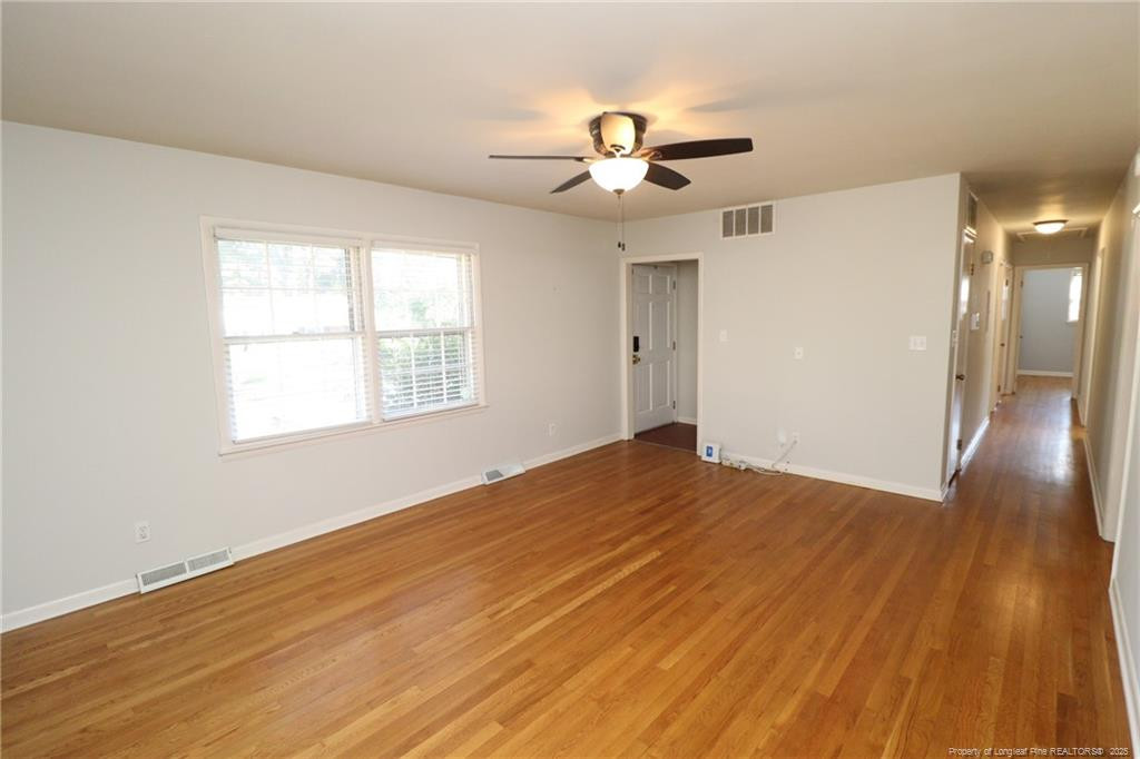 4909 Auburn Road Raleigh, NC 27609 - Photo 3 of 33 a view of an empty room with wooden floor and a window