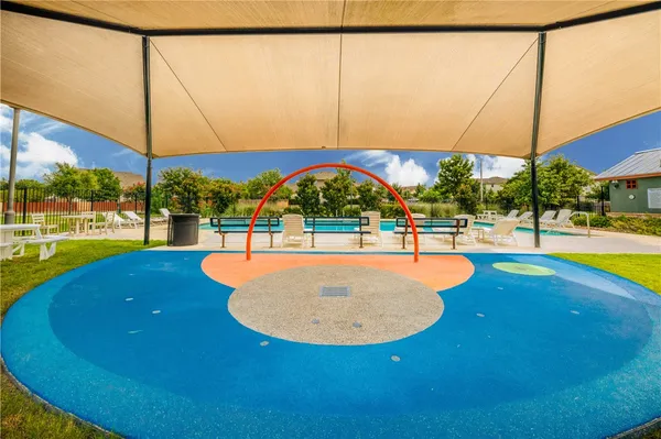 a view of swimming pool with lawn chairs and iron fence