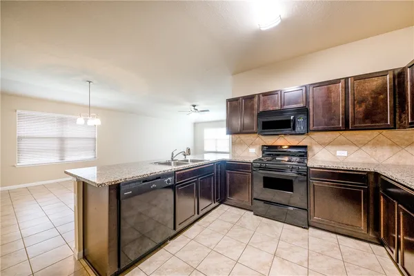 a kitchen with stainless steel appliances granite countertop a stove microwave and sink