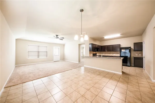 a view of a kitchen with kitchen island a sink stainless steel appliances and cabinets