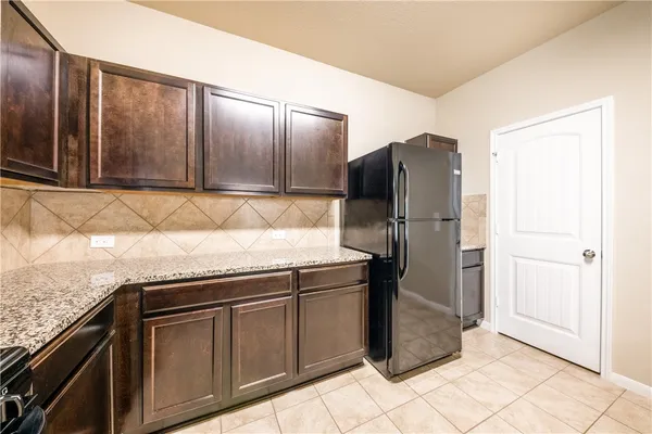 a kitchen with stainless steel appliances granite countertop a refrigerator and a stove