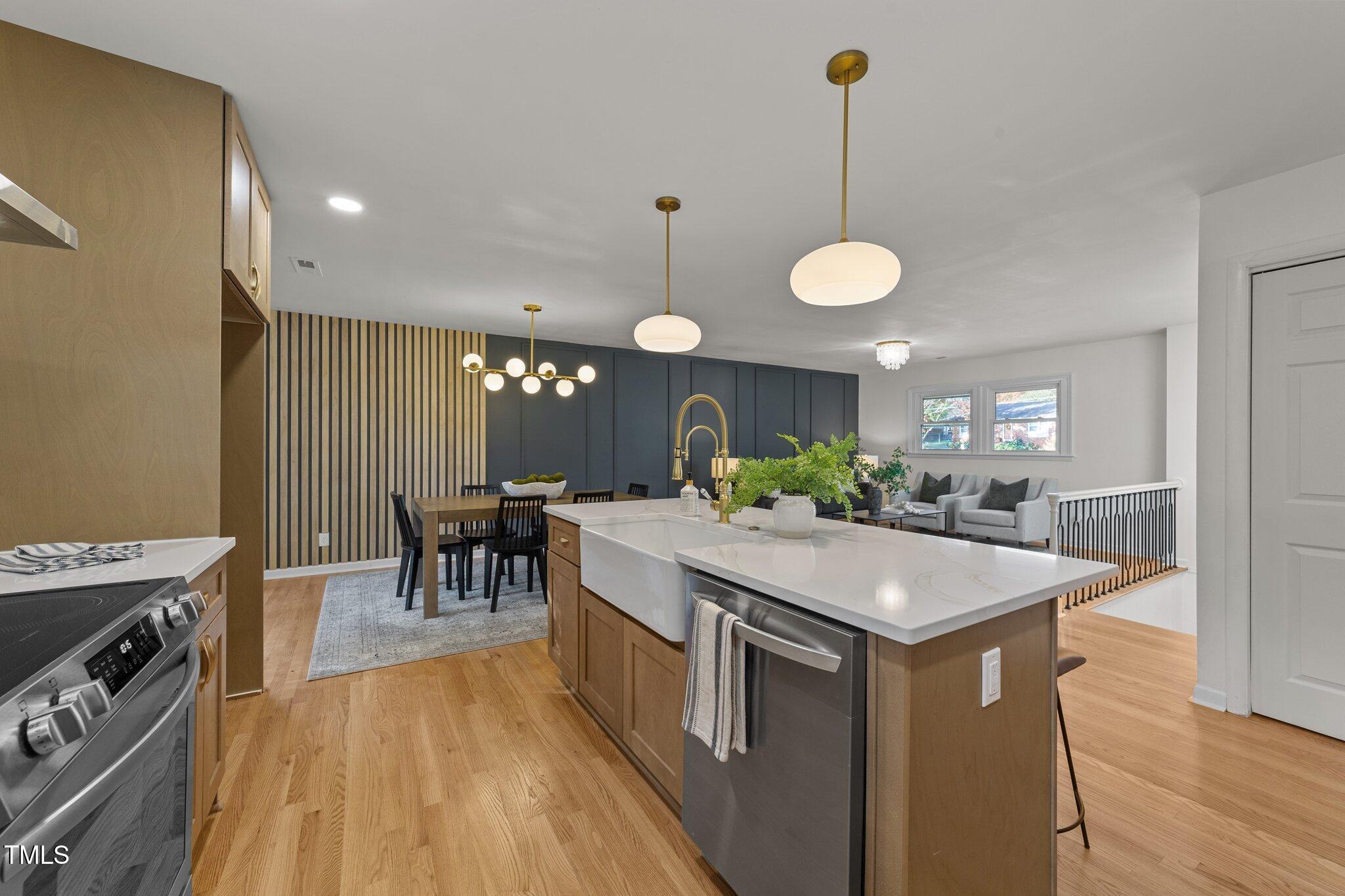 4601 Forestdale Road Raleigh, NC 27603 - Photo 13 of 46 a kitchen with stainless steel appliances granite countertop a stove top oven a dining table and chairs with wooden floor