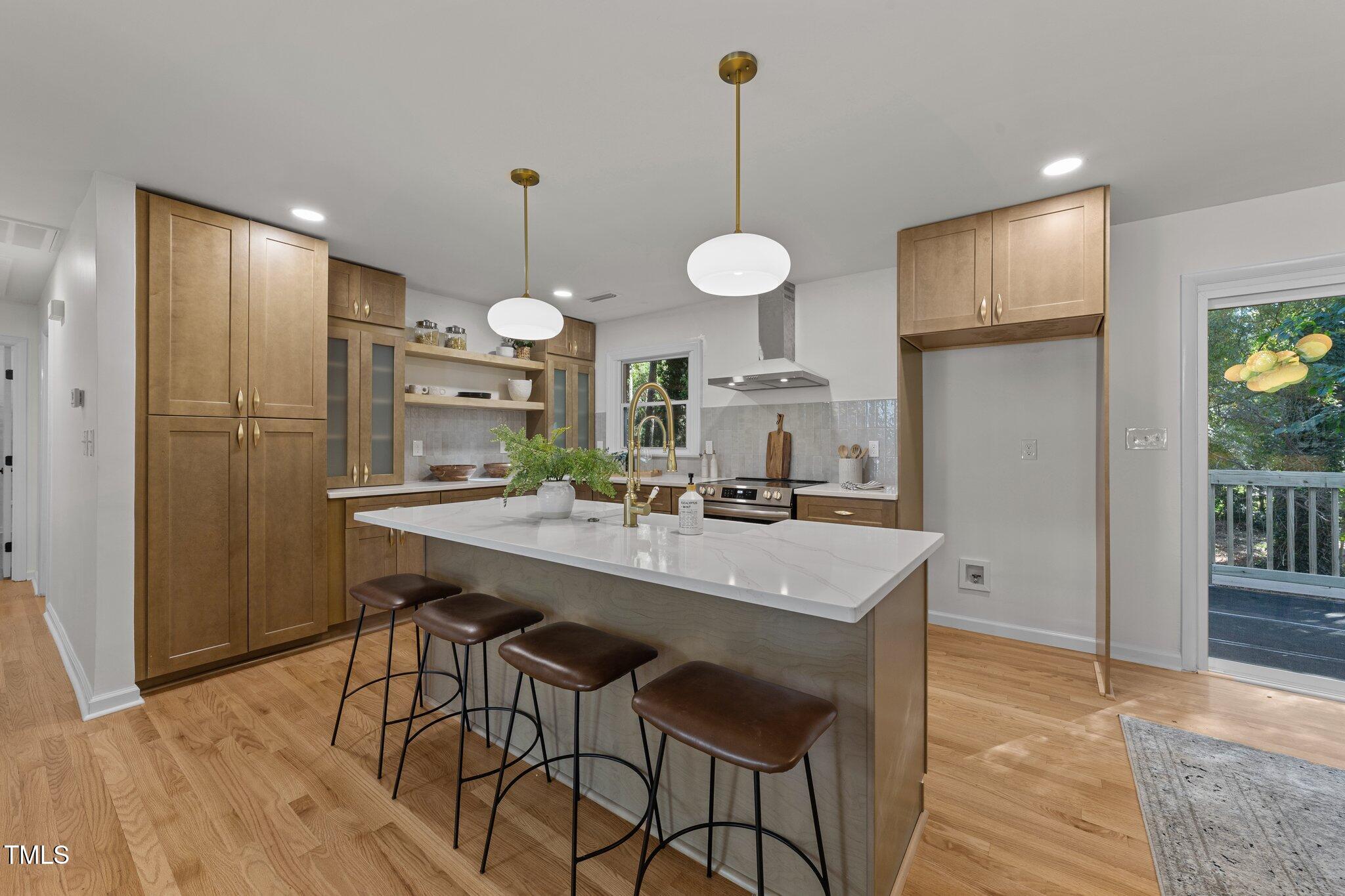 4601 Forestdale Road Raleigh, NC 27603 - Photo 16 of 46 a kitchen with stainless steel appliances kitchen island a chandelier and refrigerator