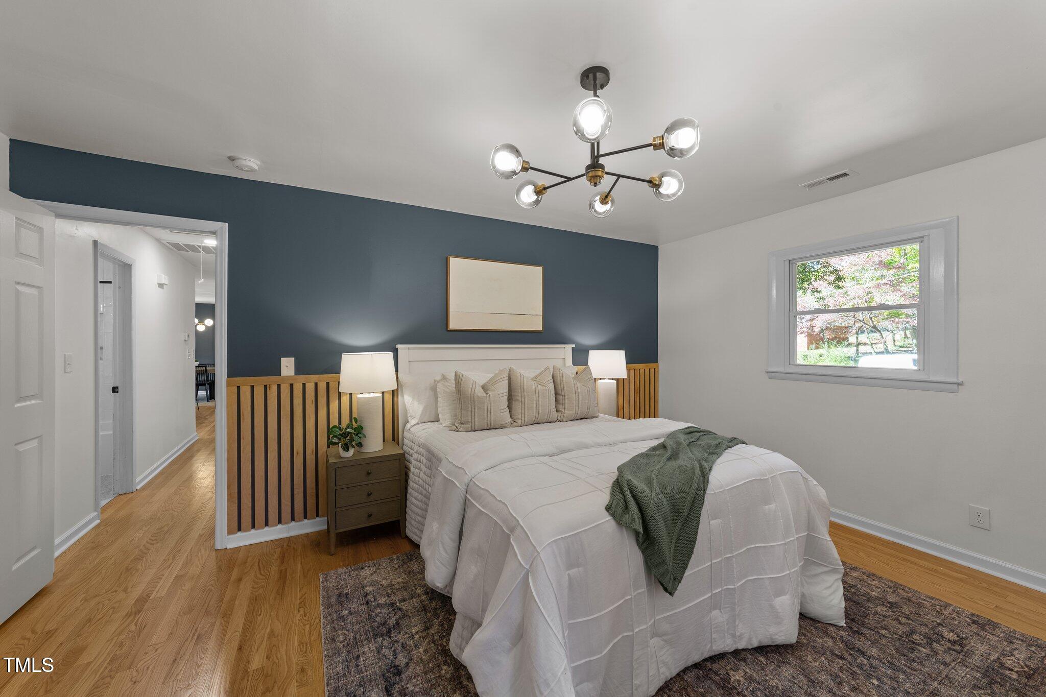 4601 Forestdale Road Raleigh, NC 27603 - Photo 20 of 46 a bedroom with a bed and a chandelier