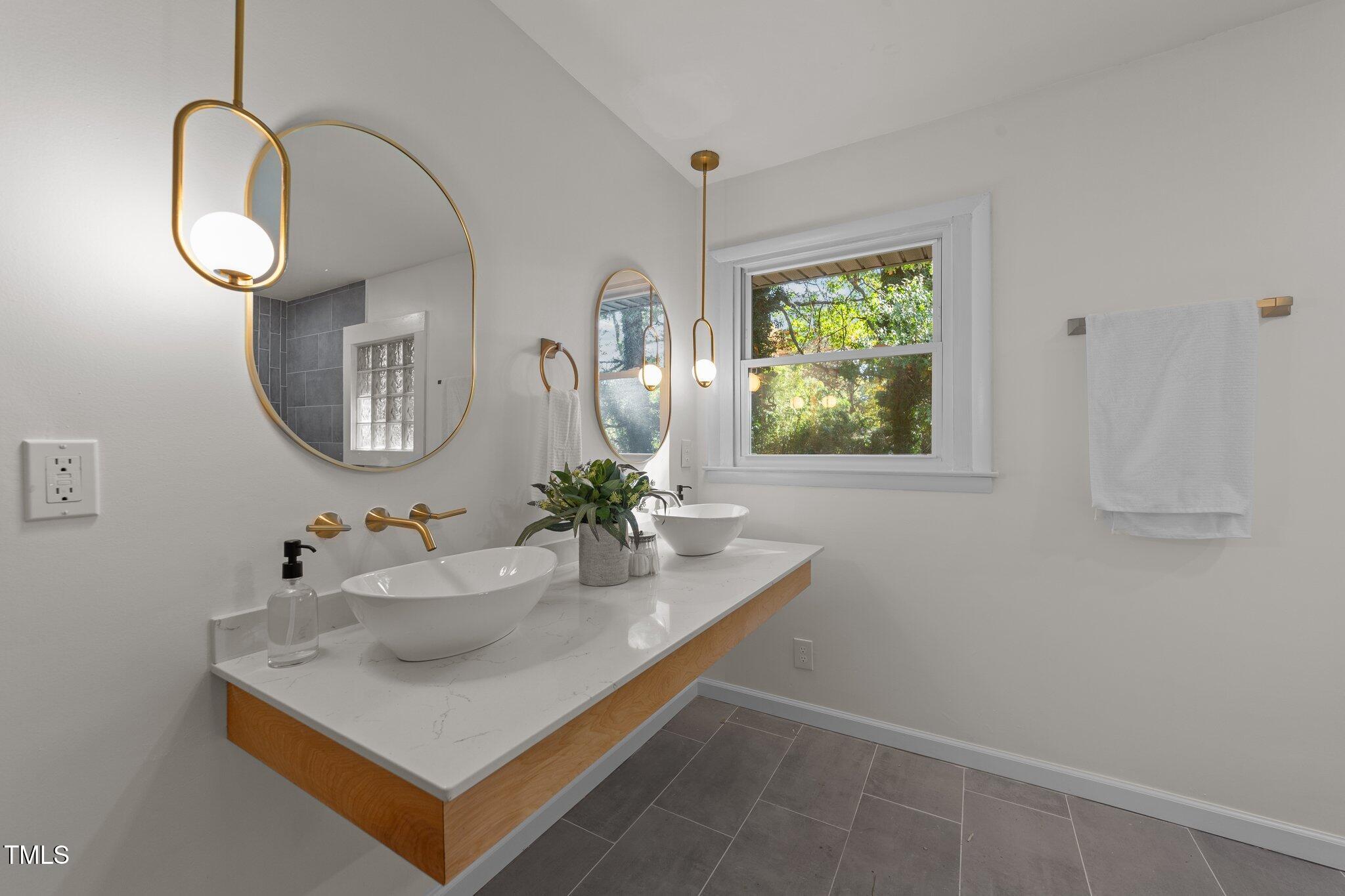 4601 Forestdale Road Raleigh, NC 27603 - Photo 22 of 46 a bathroom with a sink mirror and vanity