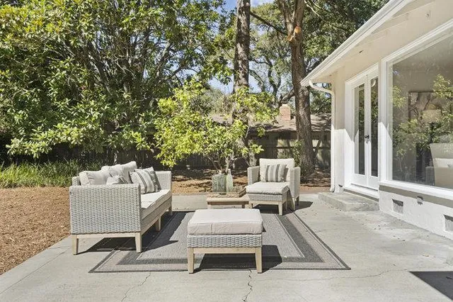 a view of a patio with couches table and chairs and potted plants
