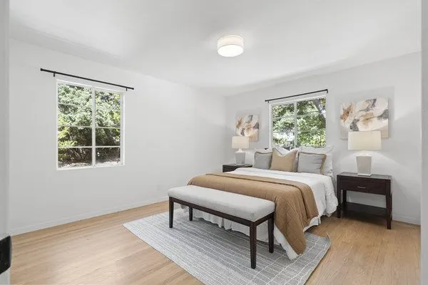 a bedroom with a bed table and a window