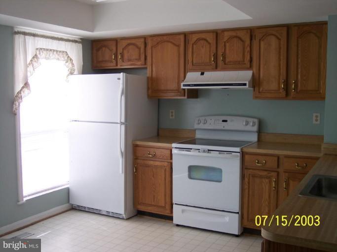 8532 Bauer Drive Springfield, VA 22152 - Photo 3 of 12 a kitchen with a refrigerator and a stove top oven