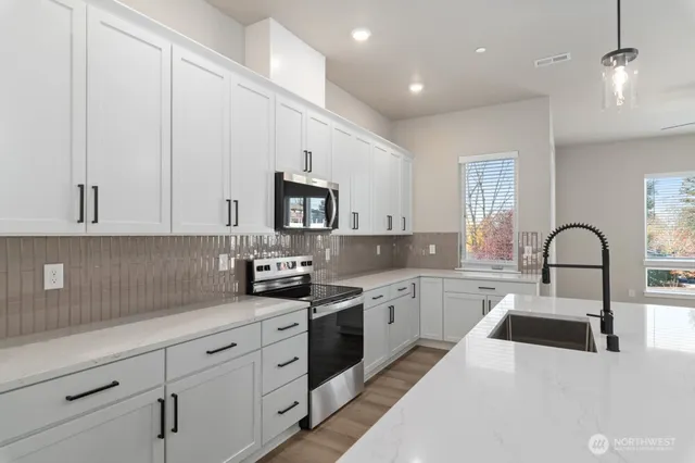 a kitchen with white cabinets a sink and appliances